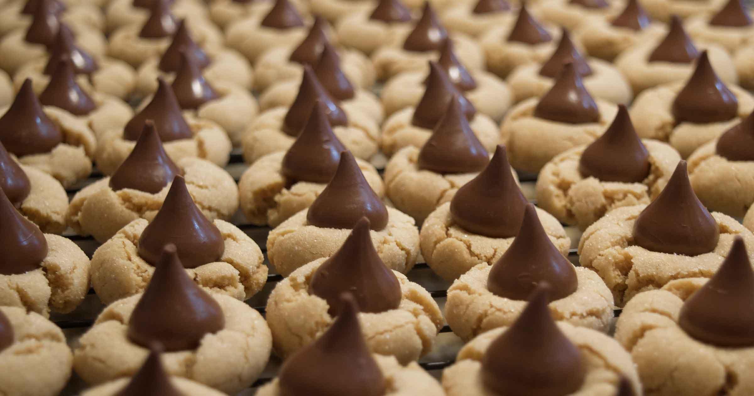 Dozens of soft-looking circular cookies with Hershey kisses in the center