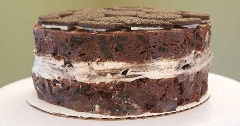 9-inch circular brownie cake that looks like a giant, thick sandwich cookie with creme filling, shown from the side